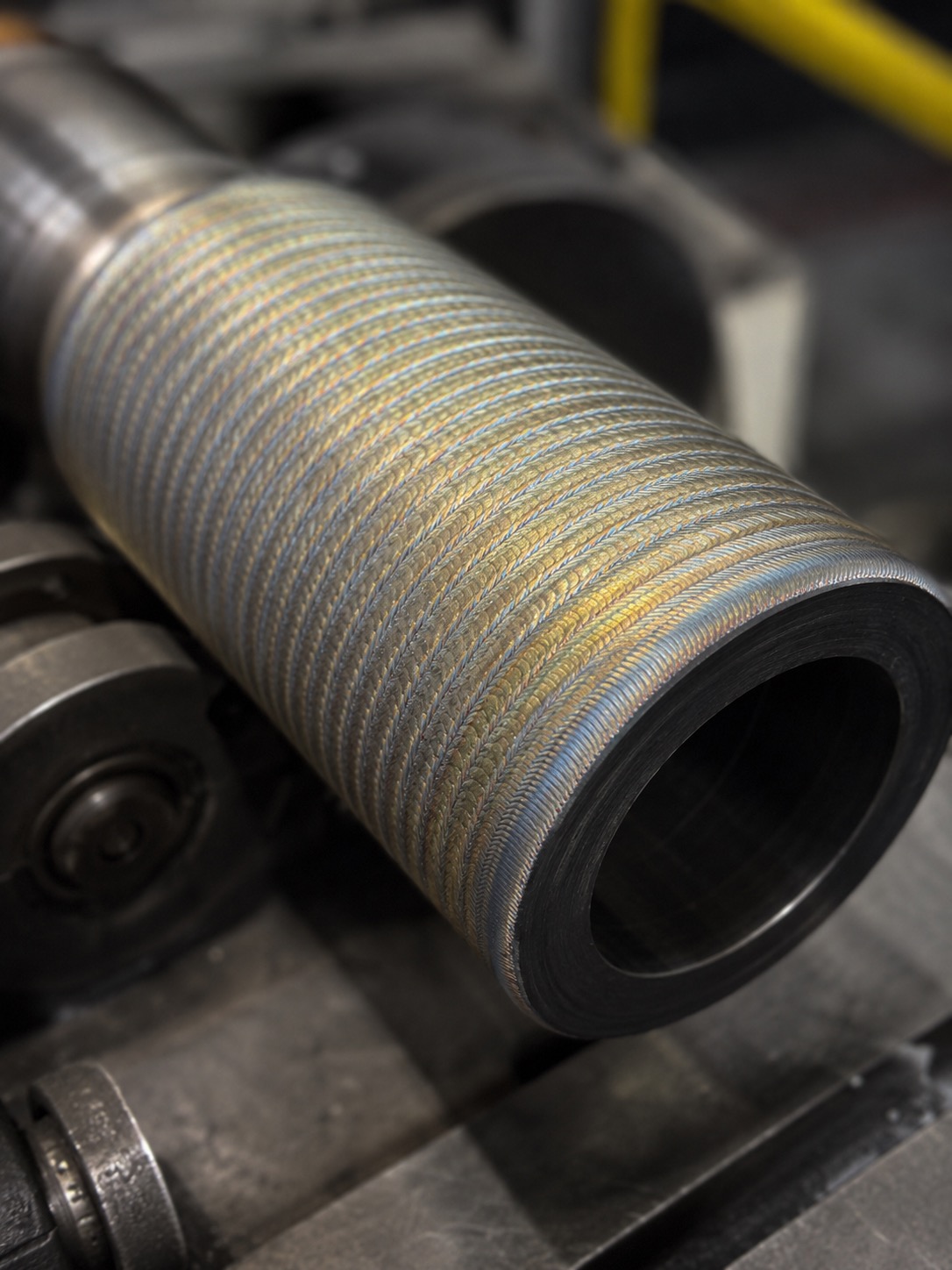 Close-up of welded hardfacing overlay on sleeve-type pump component